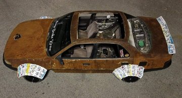 Questa Toyota Camry arrugginita ha passaruota realizzati con targhe